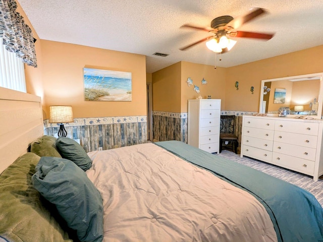 bedroom featuring ceiling fan and a textured ceiling