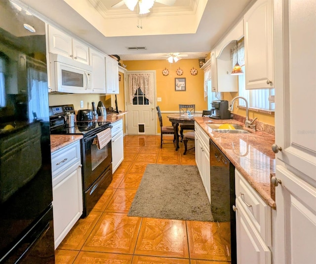 kitchen featuring white cabinetry, a tray ceiling, sink, and black appliances