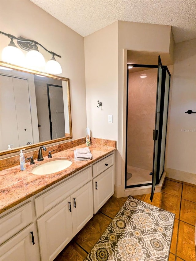 bathroom featuring vanity, tile patterned floors, a textured ceiling, and walk in shower