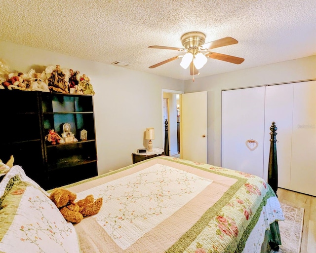 bedroom with a textured ceiling, wood-type flooring, a closet, and ceiling fan