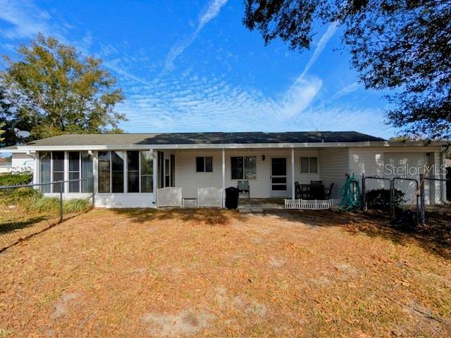 rear view of property featuring a sunroom