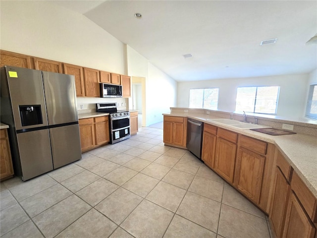 kitchen featuring stainless steel appliances, vaulted ceiling, light tile patterned floors, and sink