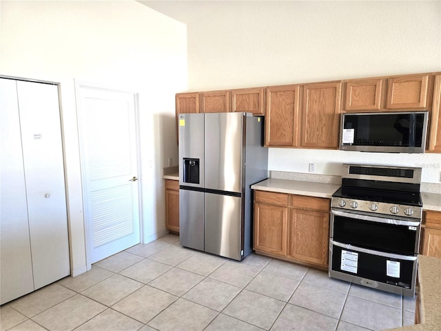 kitchen with light tile patterned floors and appliances with stainless steel finishes