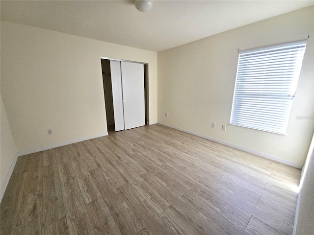 unfurnished bedroom with a closet and light hardwood / wood-style flooring