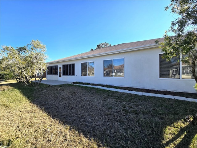 back of property with a patio area and a yard