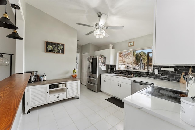 kitchen with sink, white cabinetry, hanging light fixtures, appliances with stainless steel finishes, and decorative backsplash