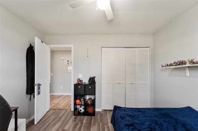 bedroom featuring a textured ceiling, wood-type flooring, a closet, and ceiling fan