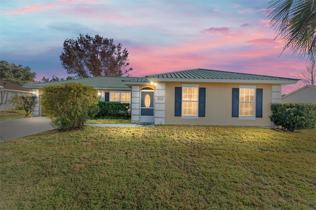 ranch-style home featuring a lawn