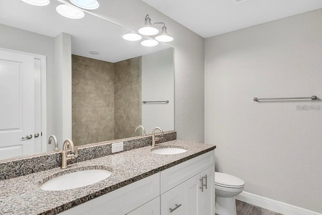 bathroom featuring toilet, wood-type flooring, and vanity