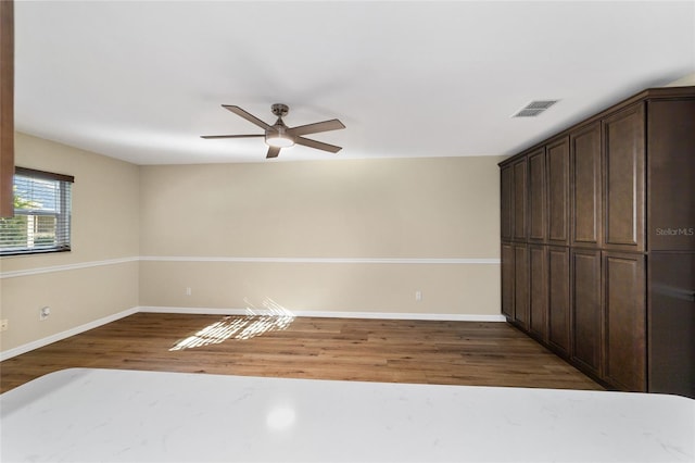 unfurnished room with ceiling fan and dark hardwood / wood-style flooring