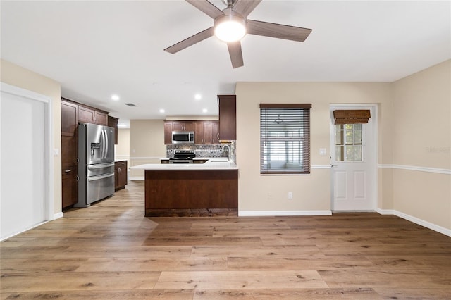 kitchen with decorative backsplash, sink, stainless steel appliances, and light hardwood / wood-style flooring