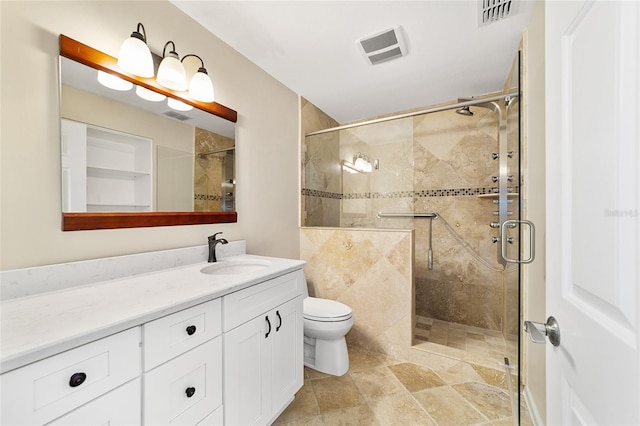 bathroom with a shower with shower door, toilet, and vanity