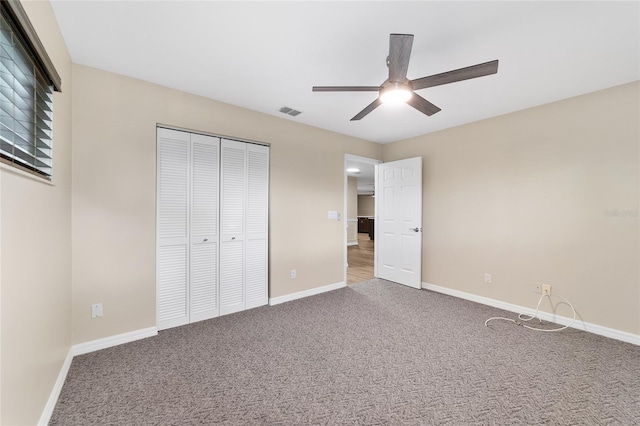 unfurnished bedroom featuring ceiling fan, carpet, and a closet