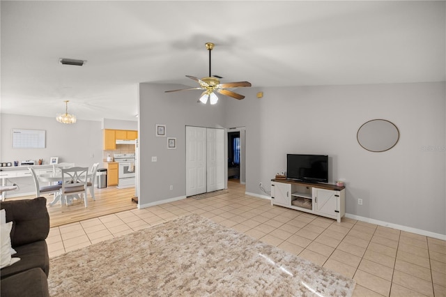 unfurnished living room featuring light tile patterned flooring and ceiling fan with notable chandelier