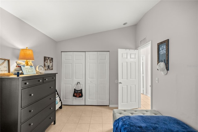 tiled bedroom featuring vaulted ceiling and a closet