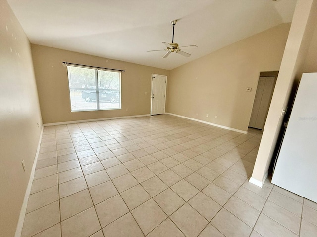 tiled spare room with ceiling fan and vaulted ceiling