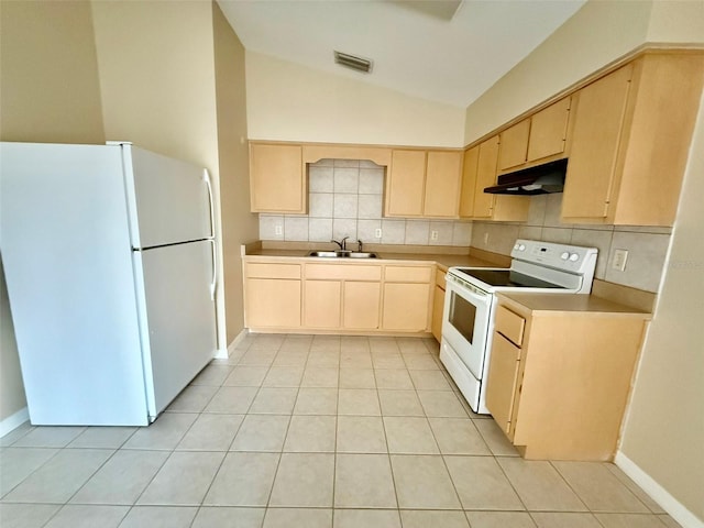 kitchen with white appliances, vaulted ceiling, sink, light tile patterned flooring, and light brown cabinets