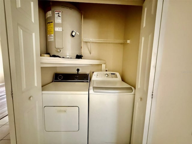 laundry area featuring water heater, separate washer and dryer, and light tile patterned floors