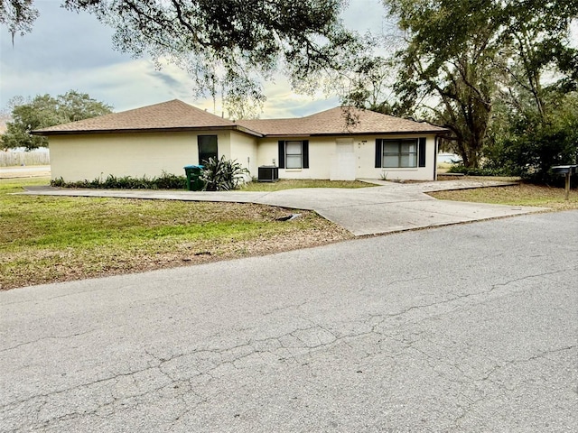 view of front facade featuring central AC and a front lawn