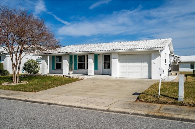 single story home with a garage and a front lawn