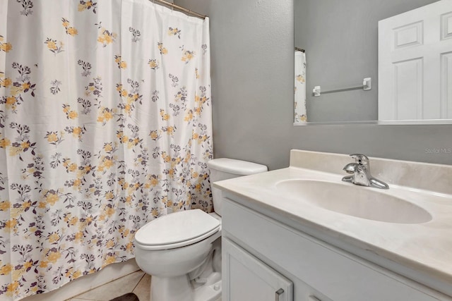 bathroom featuring toilet, vanity, and tile patterned flooring