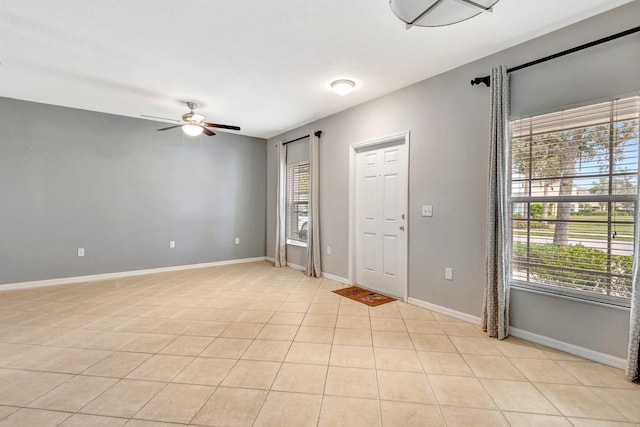 empty room with ceiling fan and light tile patterned floors