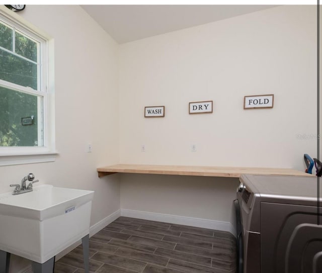 laundry area featuring sink and dark hardwood / wood-style floors