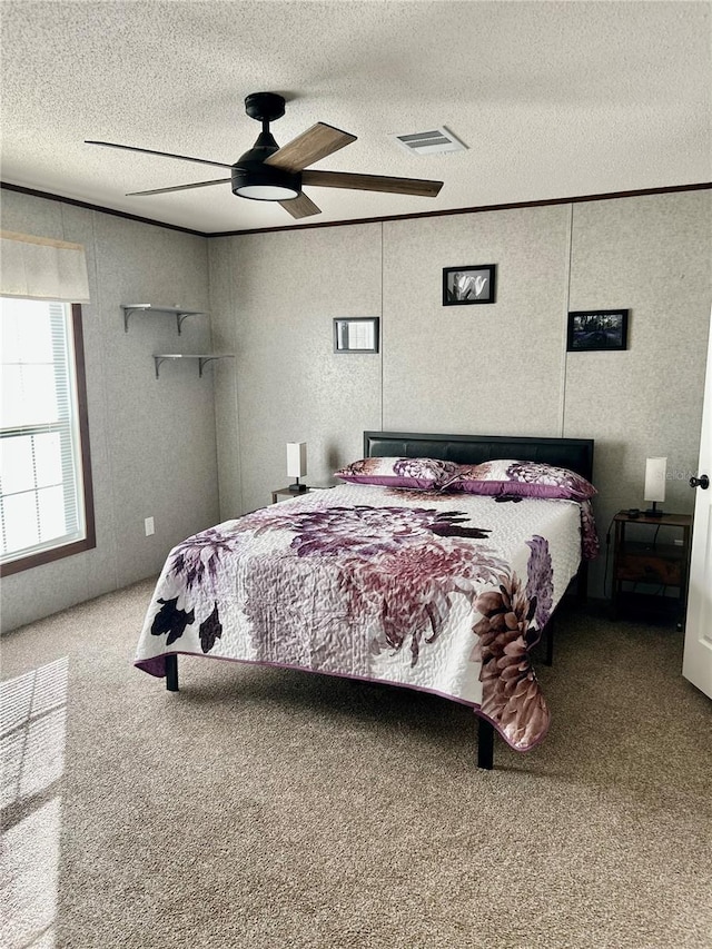 bedroom with carpet floors, ceiling fan, and a textured ceiling