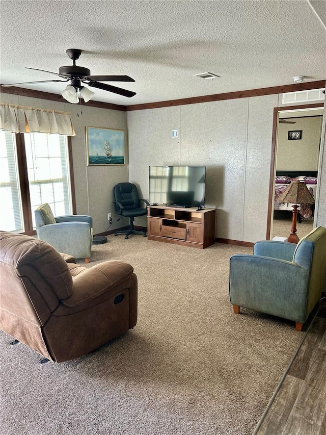 living room with hardwood / wood-style flooring, a textured ceiling, ceiling fan, and crown molding