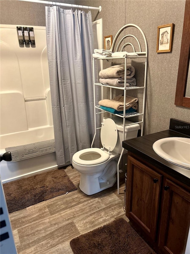 full bathroom featuring toilet, wood-type flooring, vanity, and shower / bath combination with curtain