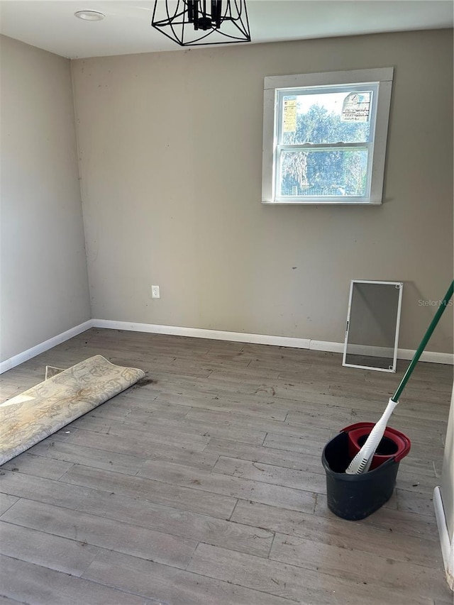 empty room featuring light hardwood / wood-style floors and a chandelier