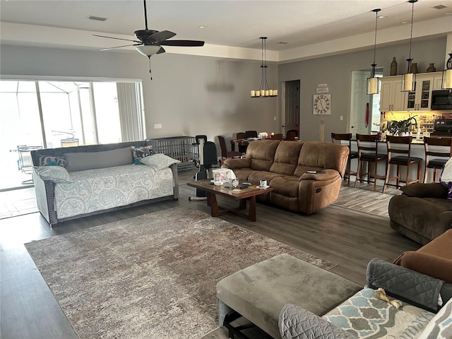 living room featuring ceiling fan and dark hardwood / wood-style flooring