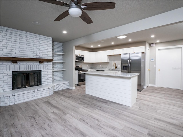 kitchen with ceiling fan, sink, white cabinets, and stainless steel appliances