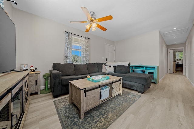 living room featuring light hardwood / wood-style floors and ceiling fan