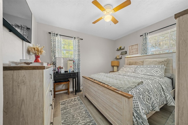 bedroom with light wood-type flooring and ceiling fan