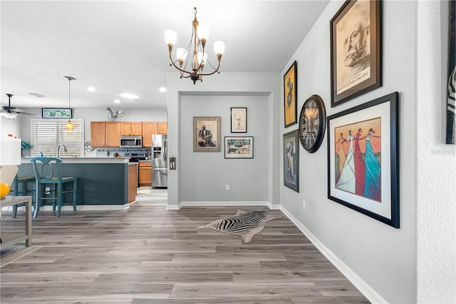 interior space with a notable chandelier, light hardwood / wood-style floors, and sink