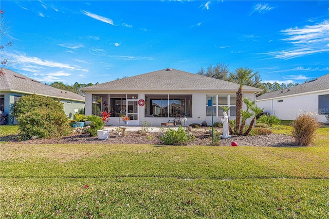 rear view of house with a lawn and a sunroom