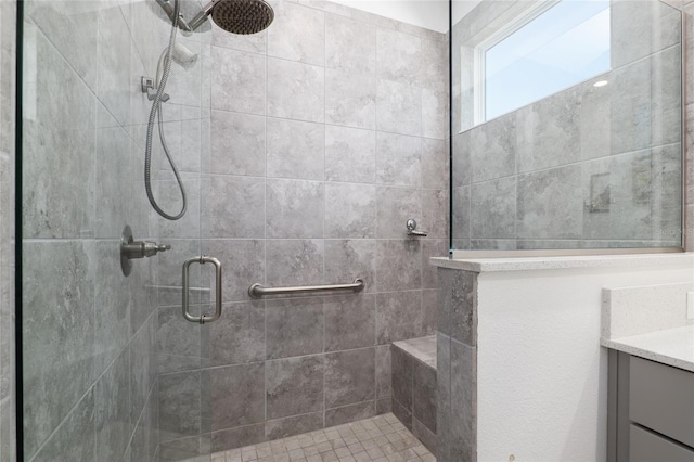 bathroom featuring a shower with shower door and vanity