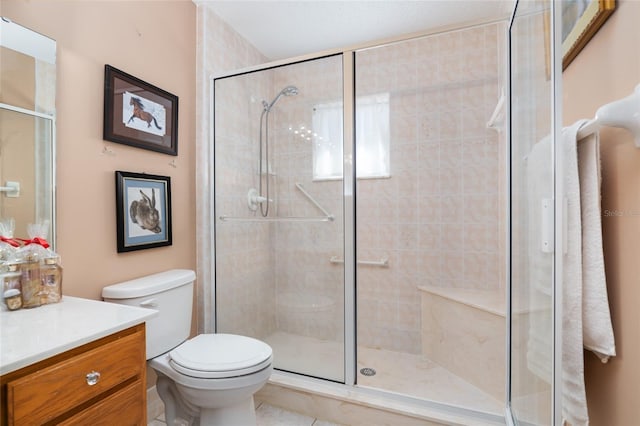 bathroom featuring tile patterned flooring, a shower with shower door, vanity, and toilet