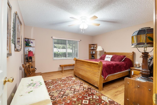 bedroom with ceiling fan, a textured ceiling, and hardwood / wood-style flooring