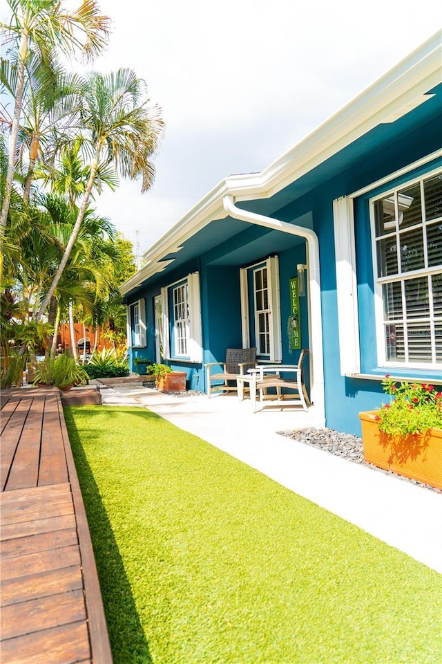 back of property featuring covered porch and a yard