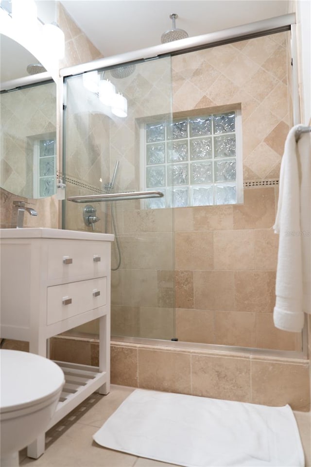 bathroom with tile patterned floors, a shower with shower door, and vanity