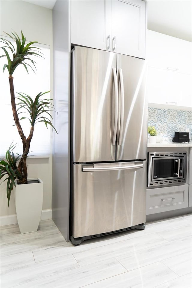 kitchen featuring tasteful backsplash, stainless steel appliances, and white cabinetry