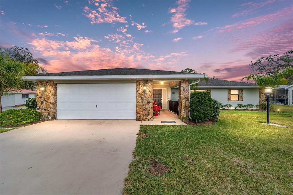 ranch-style home with a yard and a garage