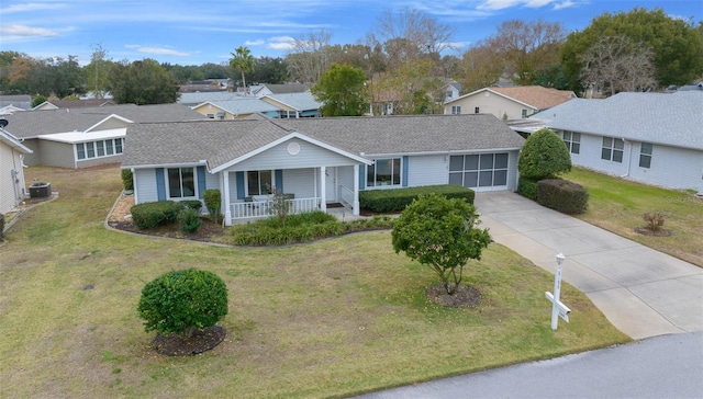 ranch-style house featuring a porch, cooling unit, and a front lawn