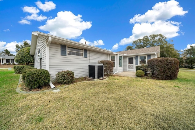 back of property with central AC unit and a lawn