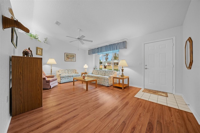 living room with ceiling fan, light hardwood / wood-style flooring, and lofted ceiling