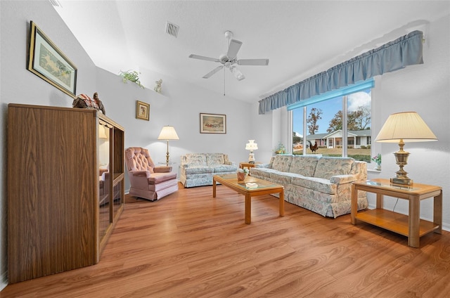 living room with ceiling fan, vaulted ceiling, and light hardwood / wood-style flooring