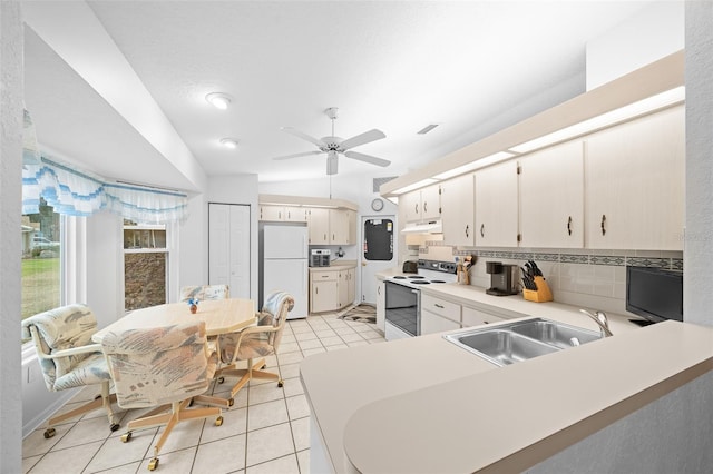 kitchen featuring white appliances, kitchen peninsula, tasteful backsplash, light tile patterned flooring, and sink