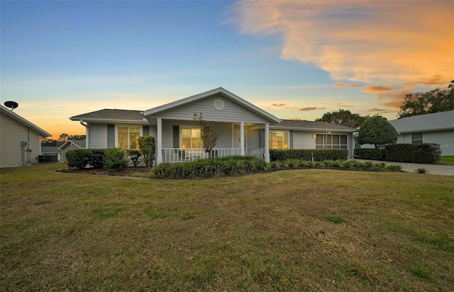 ranch-style home featuring a lawn and a porch